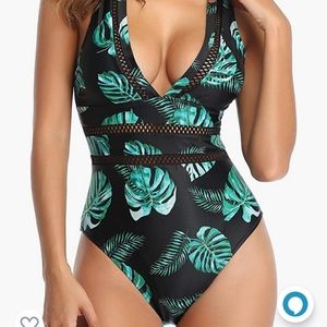 Deep v plunge swimsuit in a black and green leaf pattern